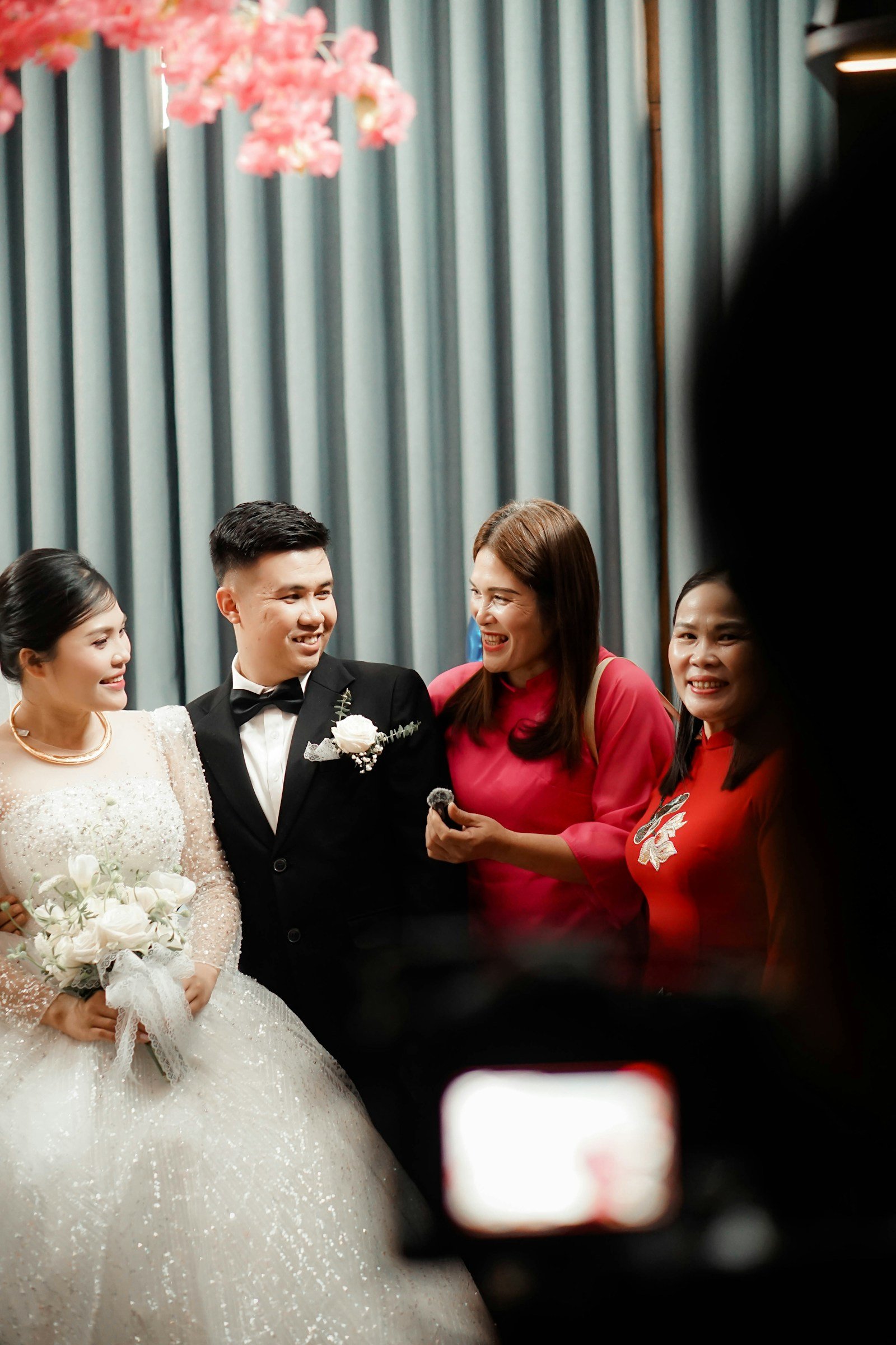 A wedding couple laughing with their family