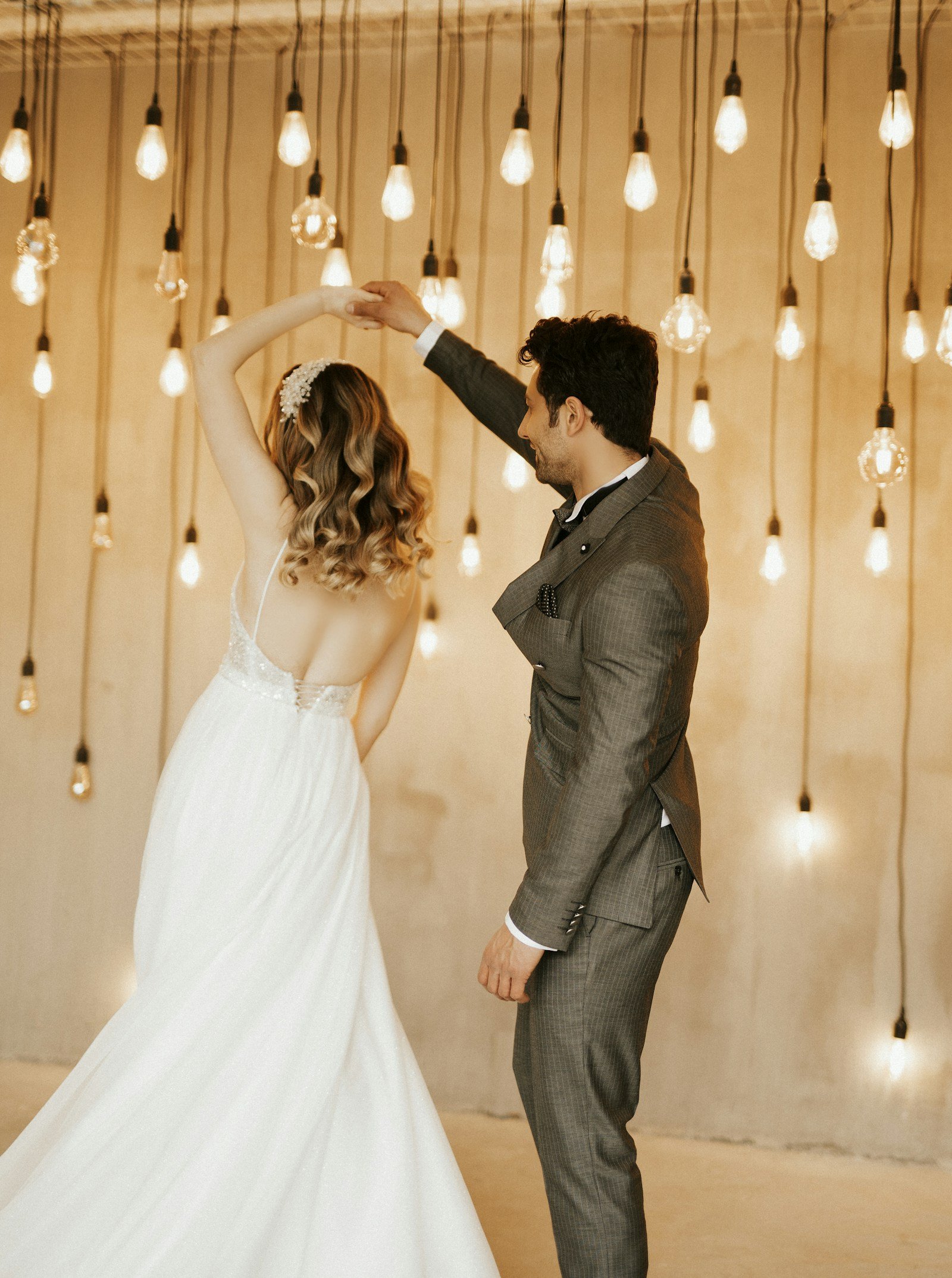 Newlyweds dancing beneath warm reception lights